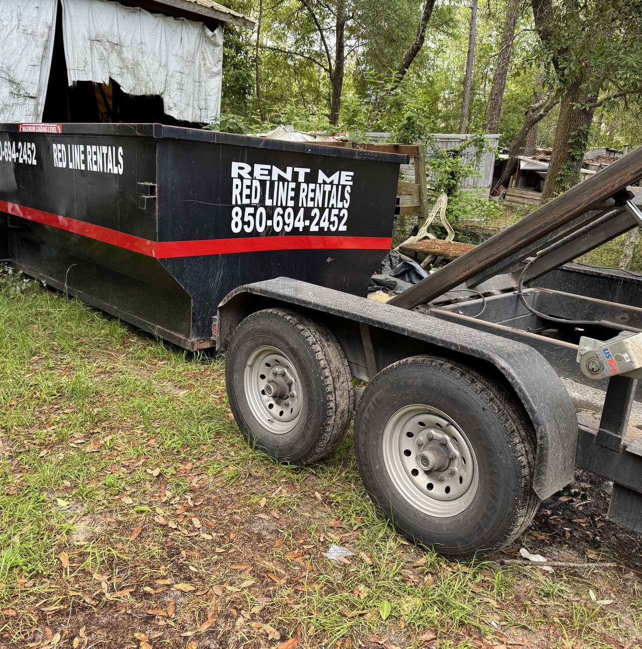 Red Line Rentals roll-off dumpster at a commercial job site in Newport, FL