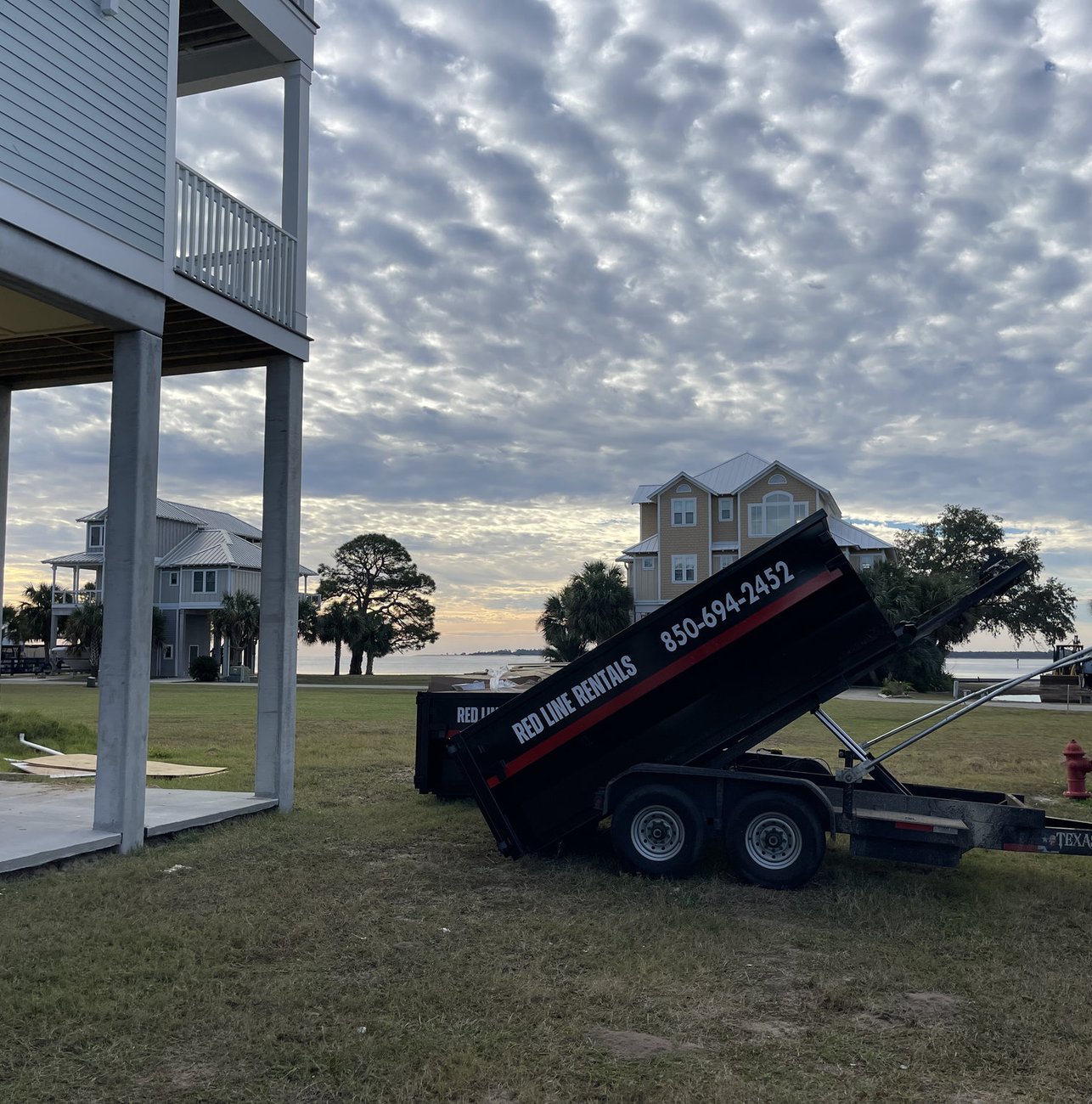 Red Line Rentals roll-off dumpster on a Sopchoppy, FL job site