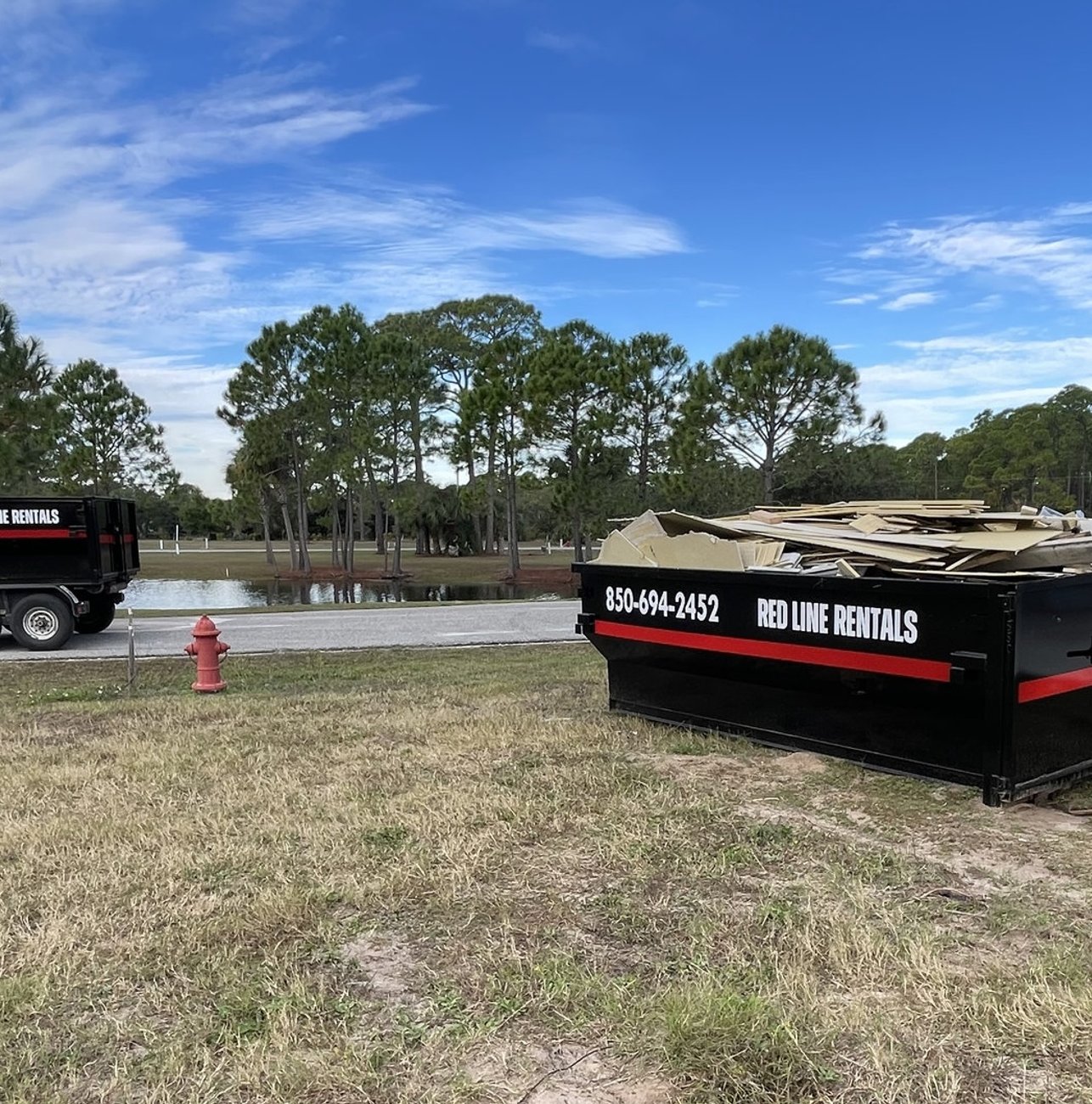 Red Line Rentals roll-off dumpster ready for pickup in Lanark Village, FL