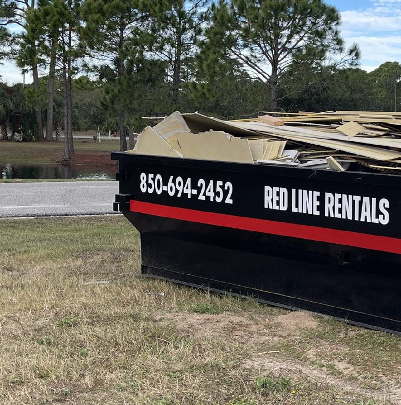 Red Line Rentals roll-off dumpster ready for pickup in Shadeville, FL