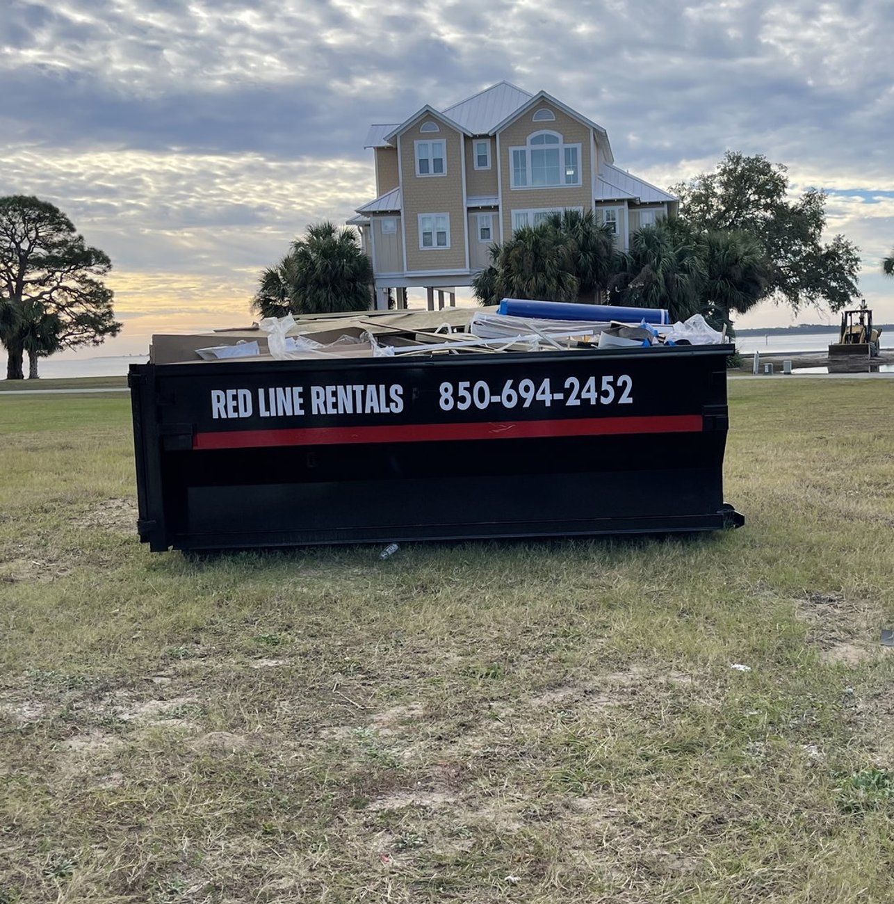 Red Line Rentals roll-off dumpster on a Carrabelle, FL job site