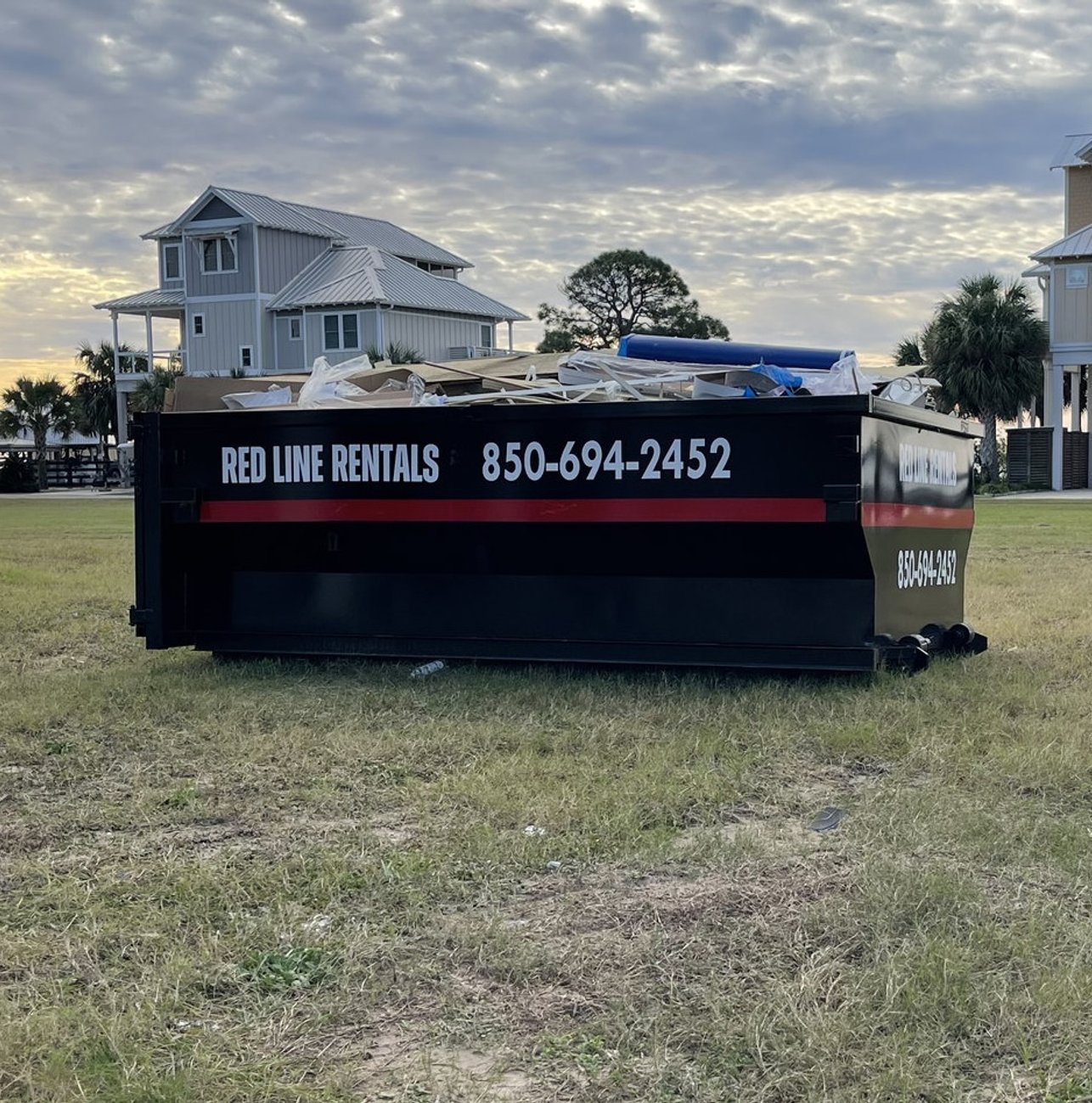 Red Line Rentals roll-off dumpster at a commercial job site in Panacea, FL