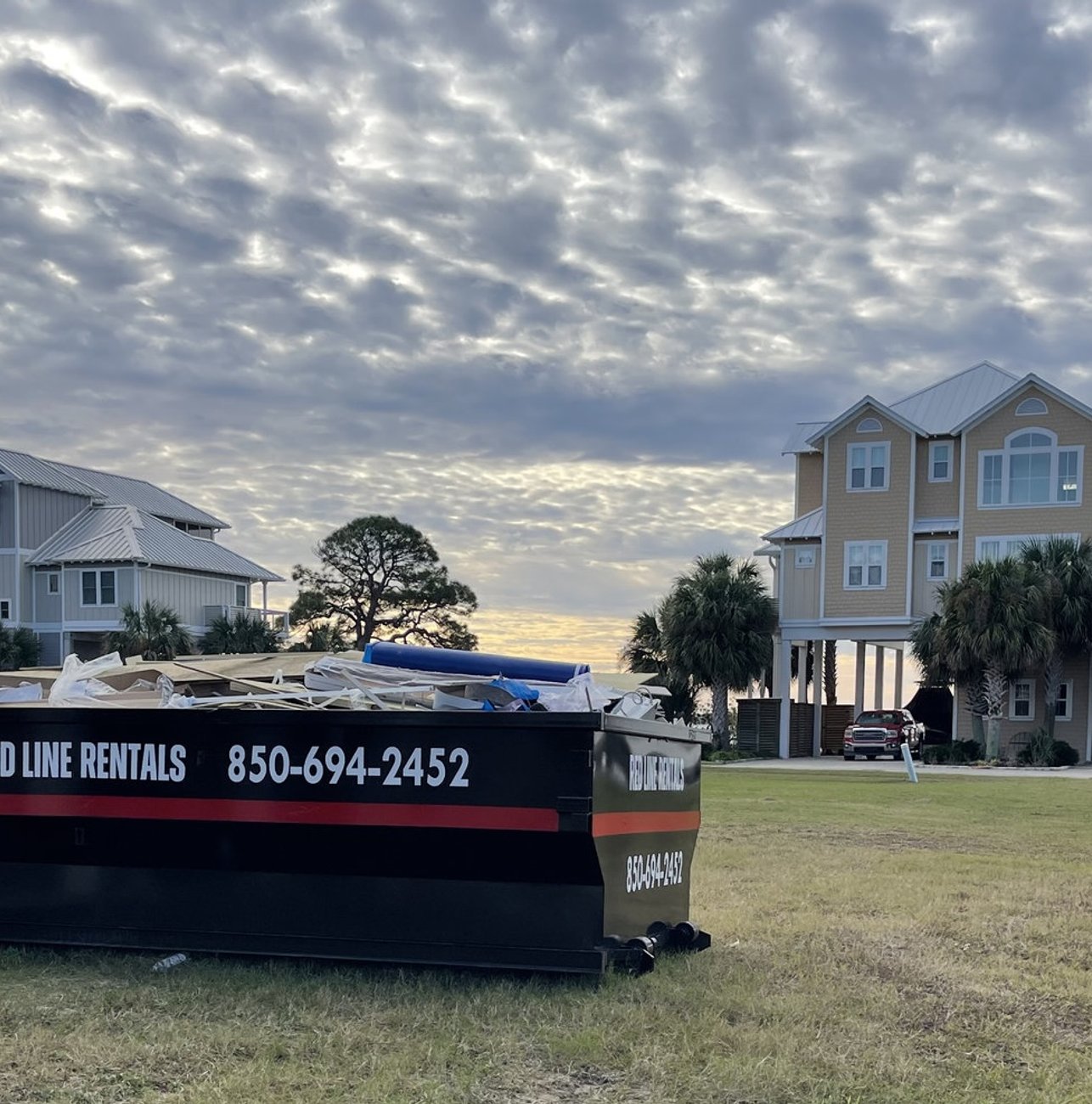 Red Line Rentals roll-off dumpster on a Lanark Village, FL job site