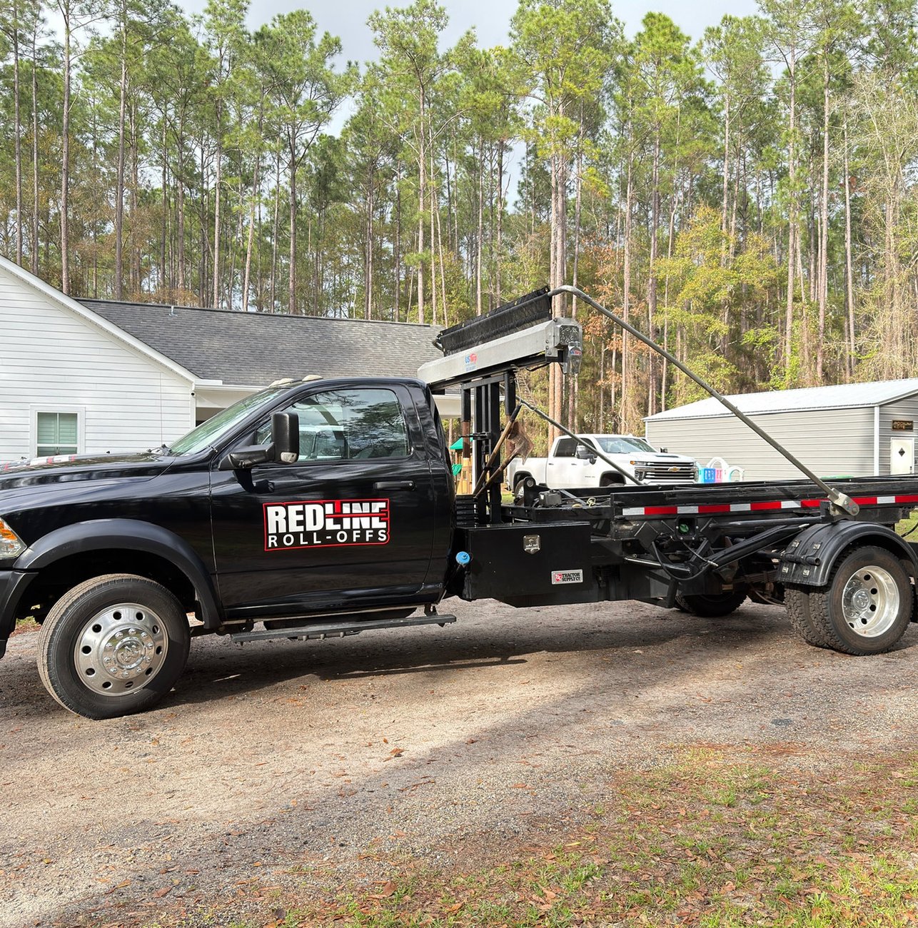 Red Line Rentals roll-off dumpster at a residential cleanout in Ochlockonee, FL